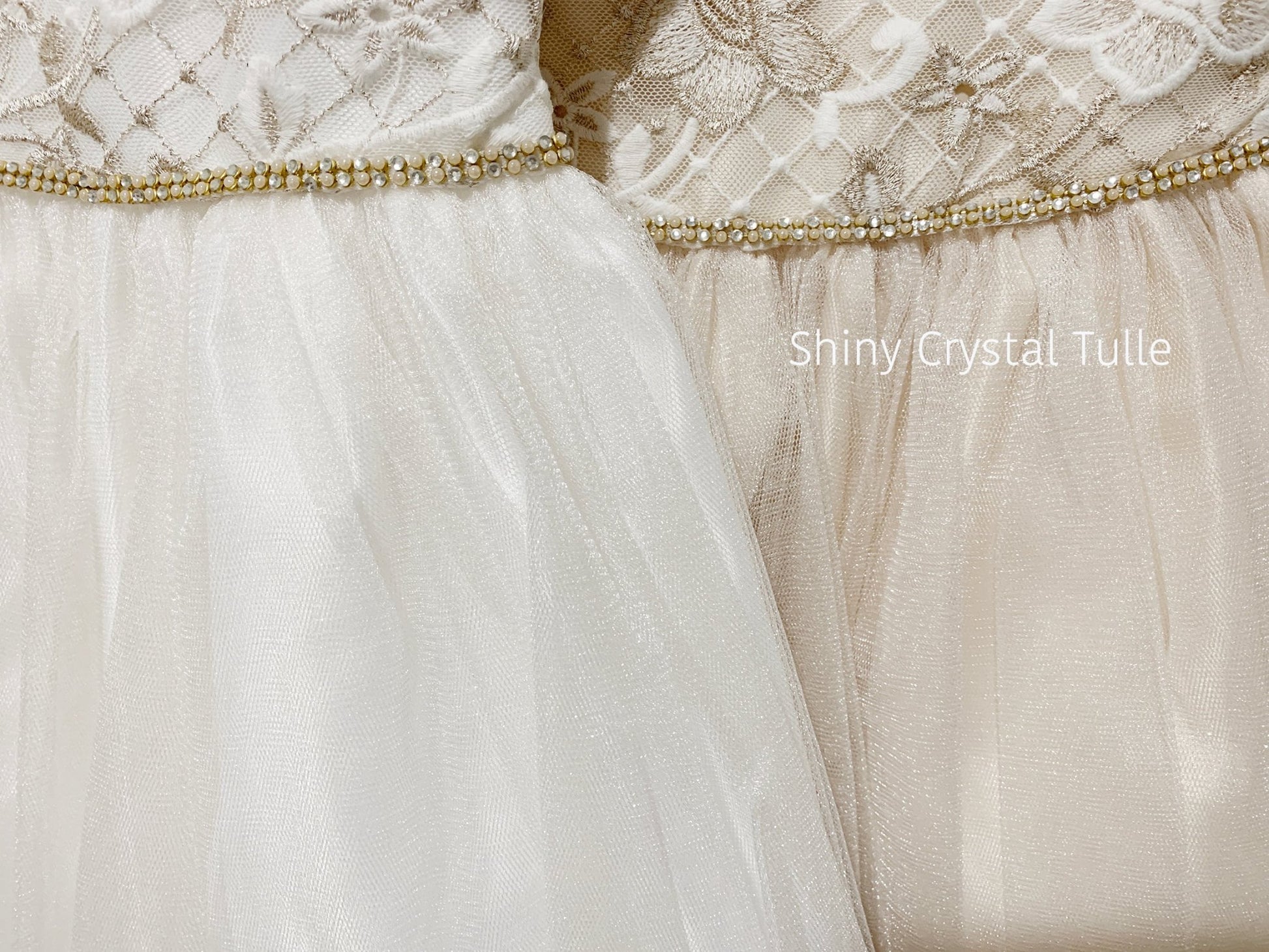 Close-up of a white and champagne lace dresses together with a shiny crystal tulle trim