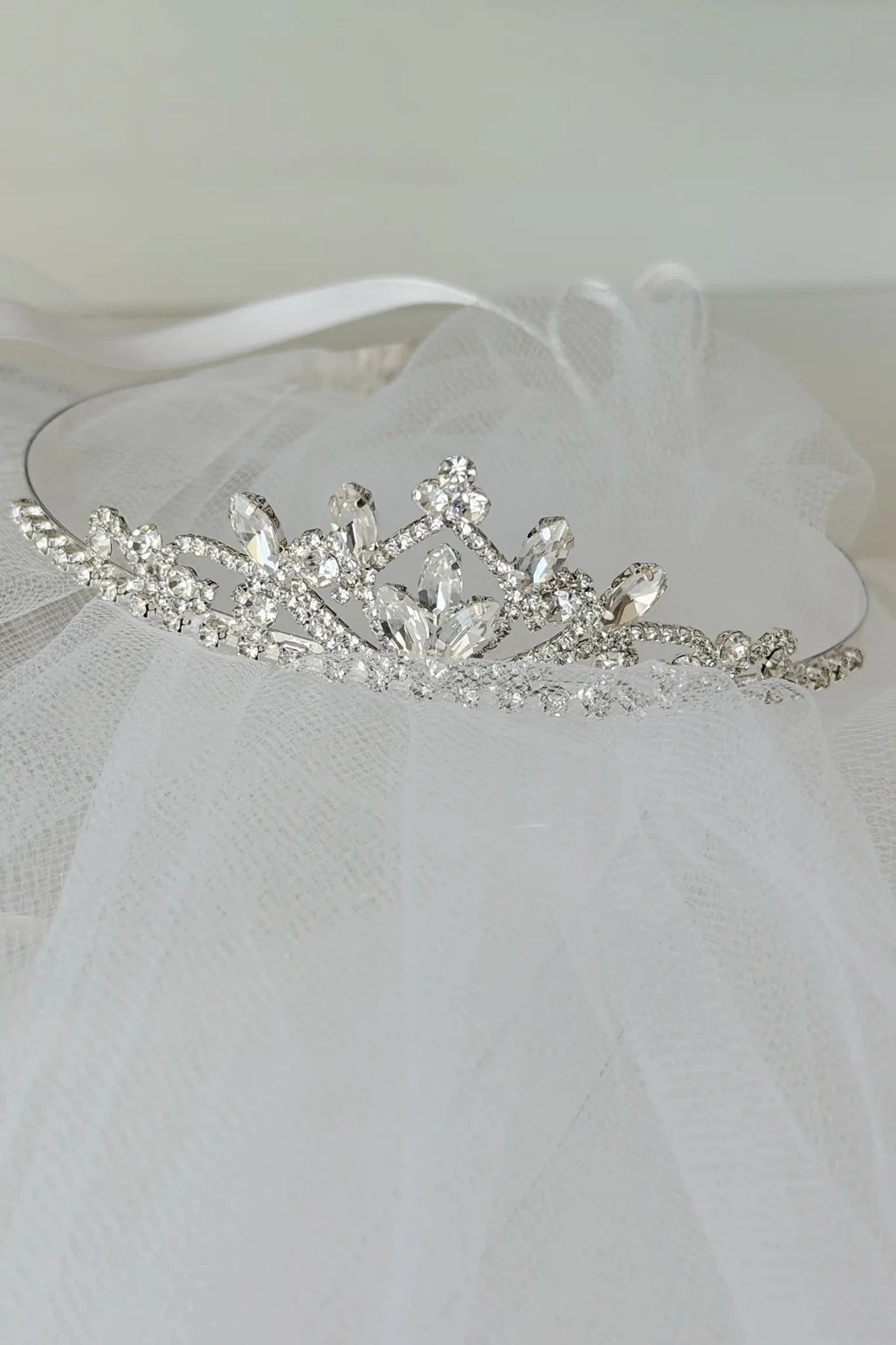 Silver tiara with crystals on a white veil