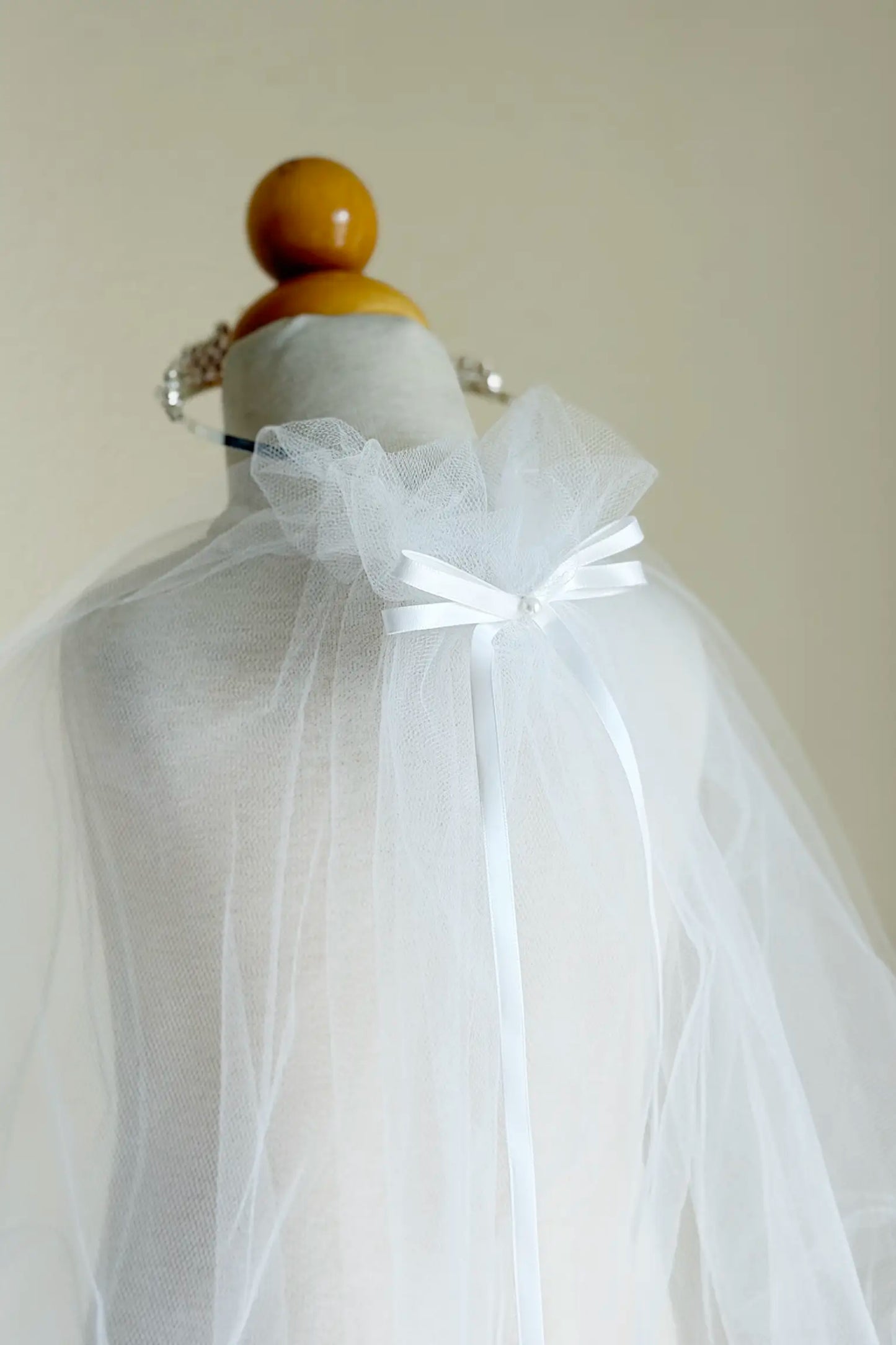 White tulle fabric on a mannequin with a plain background