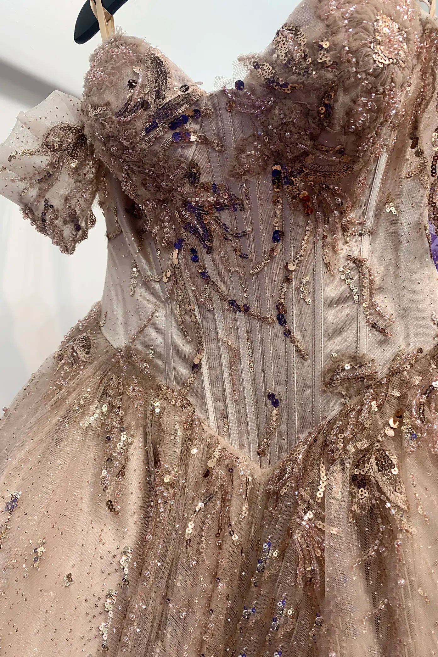Elaborate mauve quince  gown with intricate detailing on a white backgroundall