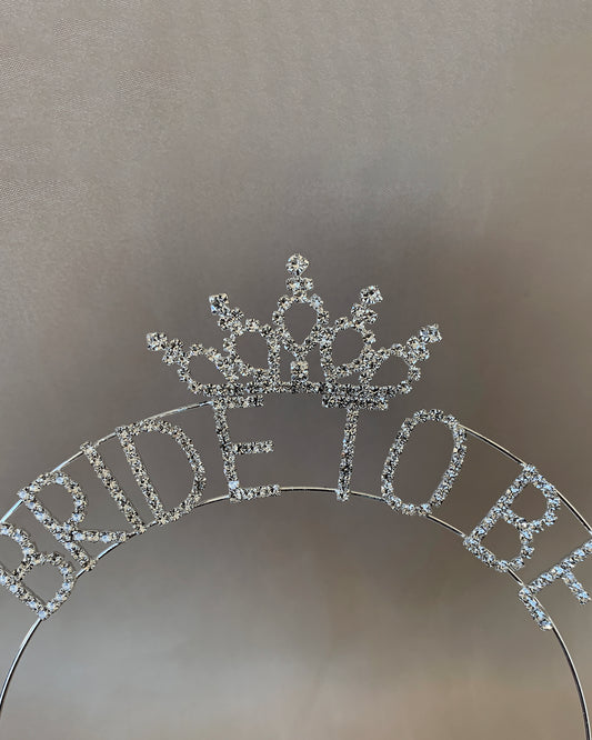 Silver 'Bride to Be' tiara on a reflective surface