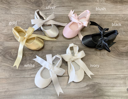 Set of ballet shoes with ribbons in various colors on a wooden surface
