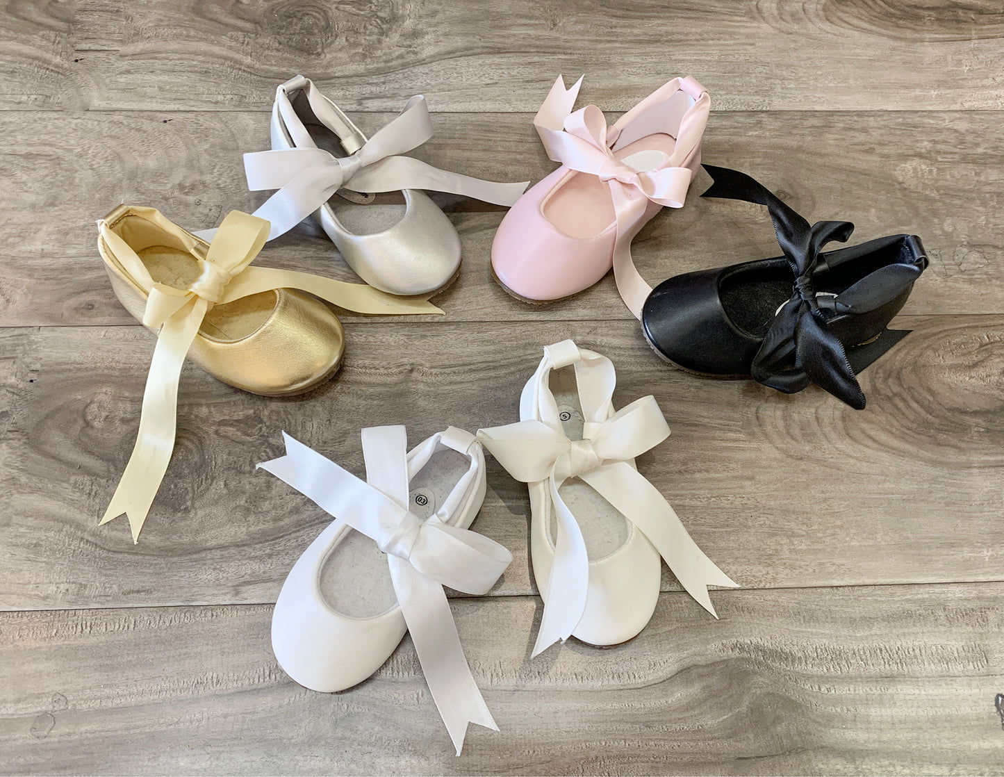 Set of ballet shoes with ribbons on a wooden surface