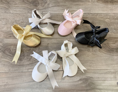 Set of ballet shoes with ribbons on a wooden surface