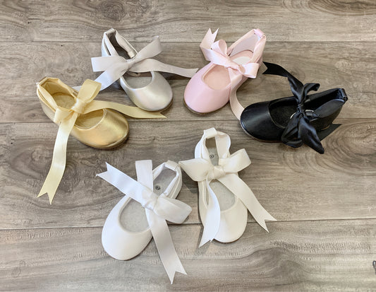 Set of ballet shoes with ribbons on a wooden surface
