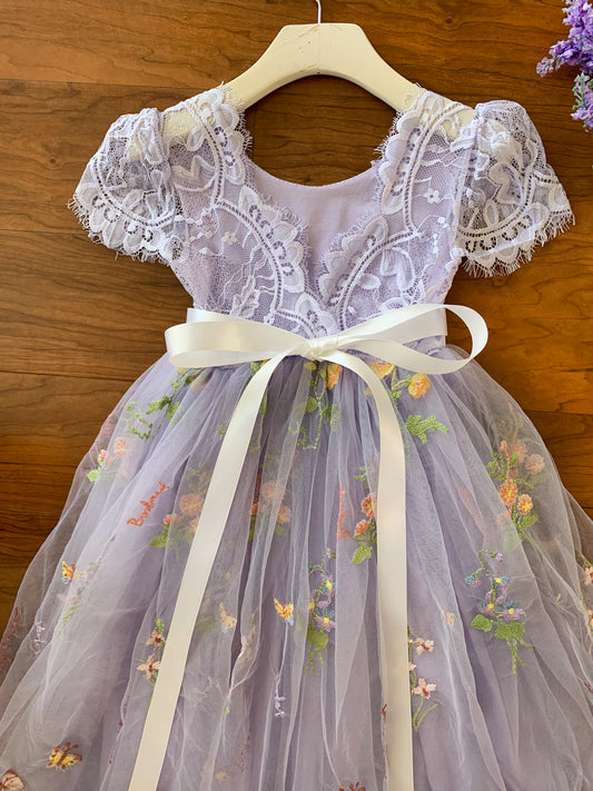 Lavender lace dress with floral embroidery on a wooden background