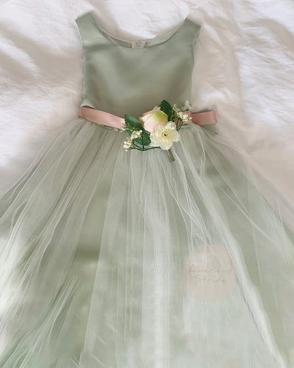 sage dress with a floral sash on a white fluffy surface