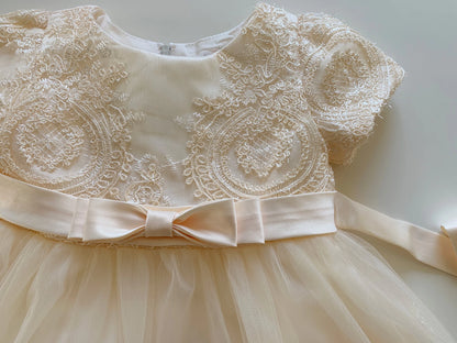 champagne lace dress with a bow on a white background