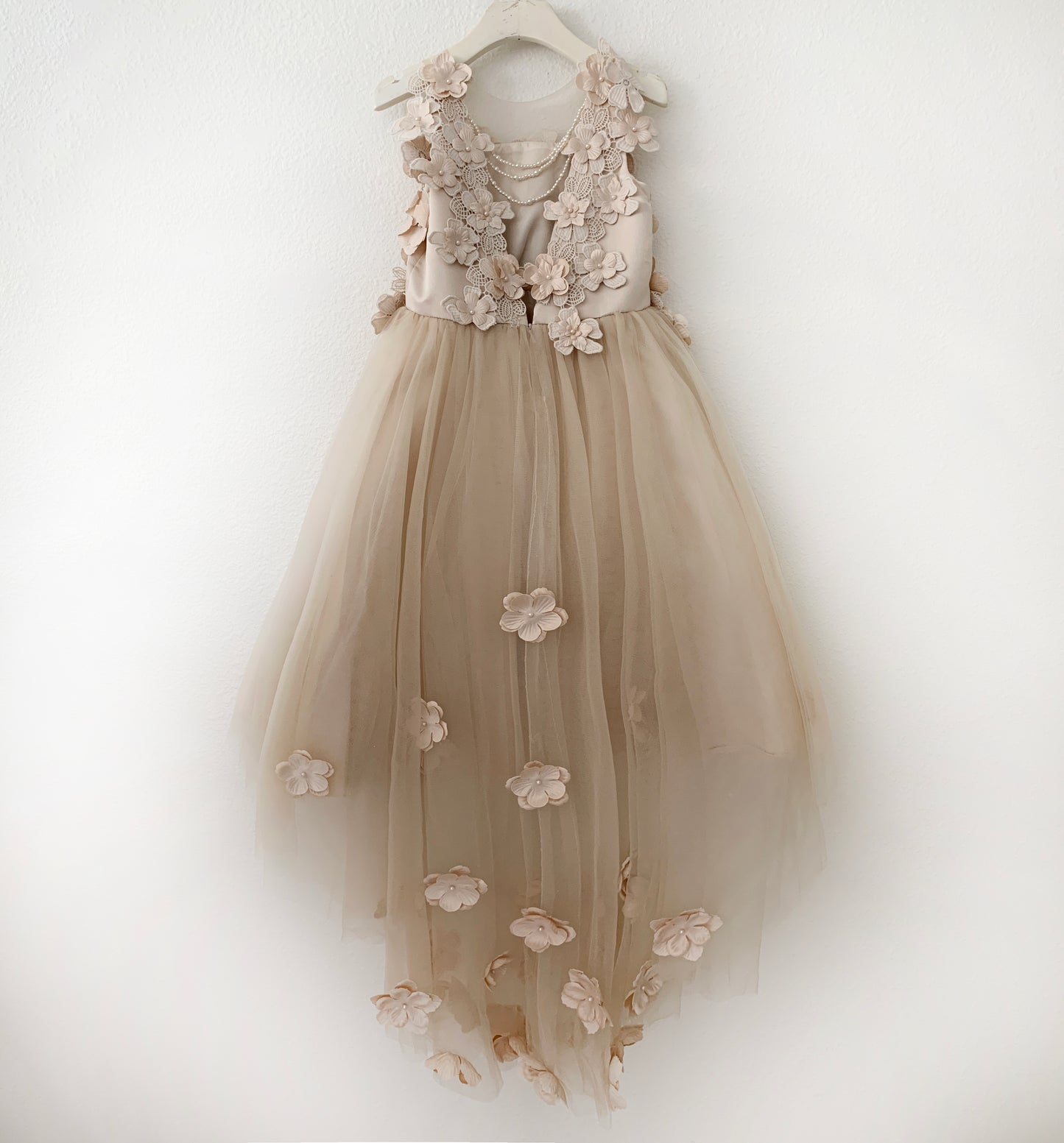 Beige floral dress on a white hanger against a white background