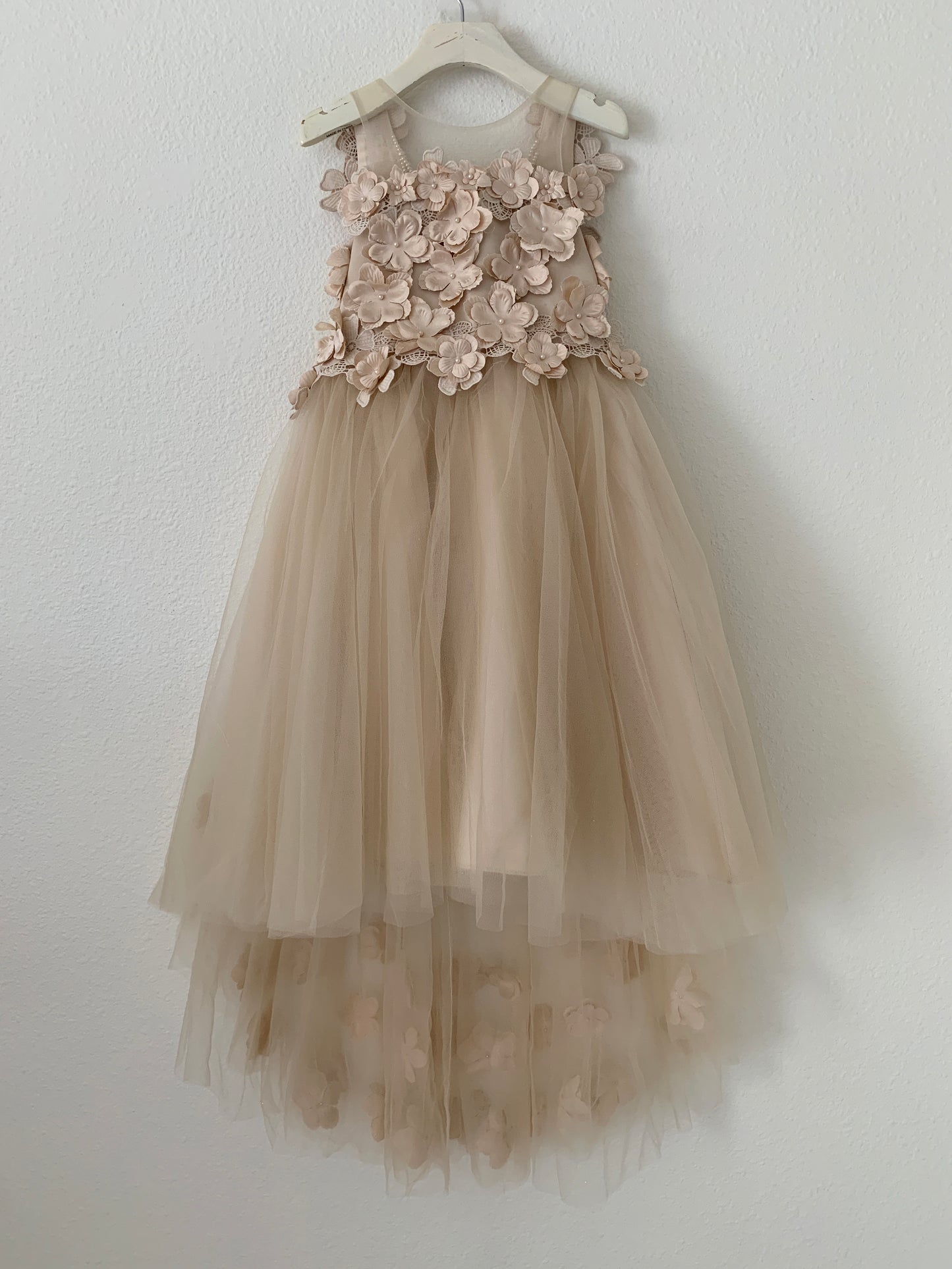 Champagne High-Low Tulle Dress with 3D Flower Lace Top Accentuated with Pearl Trim Flower Girl Dress | Flower Girl Dress - front view of dress on hanger