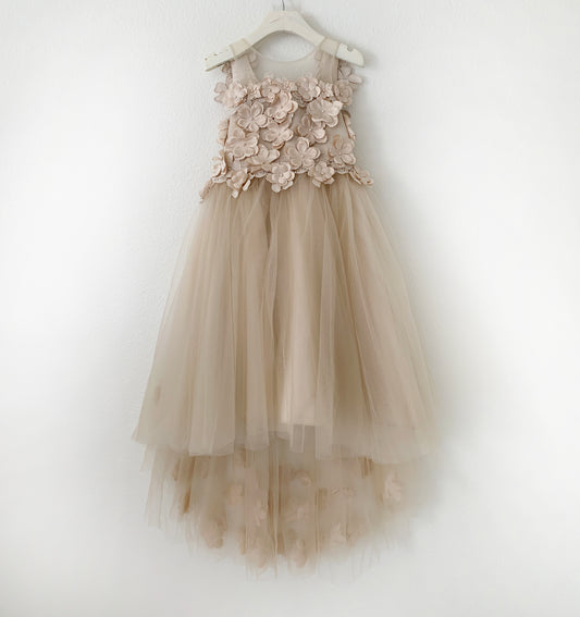 Beige flower girl dress with floral details on a white hanger against a white background