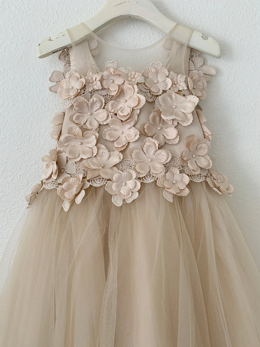 Beige flower girl dress with floral lace details on a white hanger against a white background