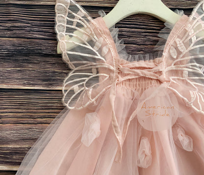 Pink fairy dress with butterfly wings on a wooden surface, brand 'American Stride' visible.