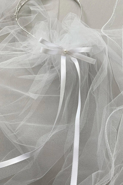White tulle fabric with ribbons on a gray background