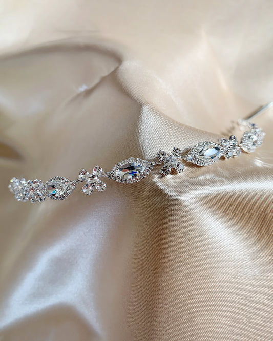 Elegant rhinestone headpiece on a soft beige fabric background