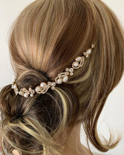 Hair accessory with pearls and crystals in a braided hairstyle on a neutral background