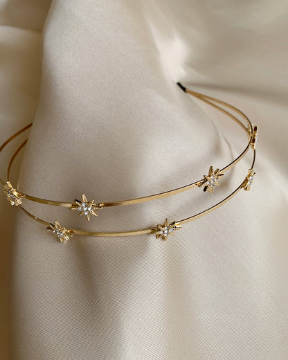 Gold headband with star shaped and rhinestone on a neutral background