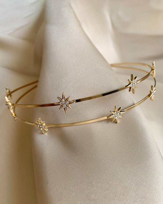 Gold headband with star-shaped on a beige fabric background