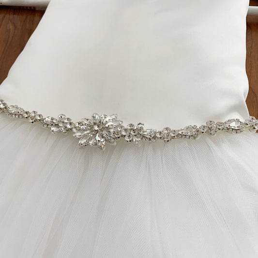 White tulle satin dress with a decorative silver belt on a white background