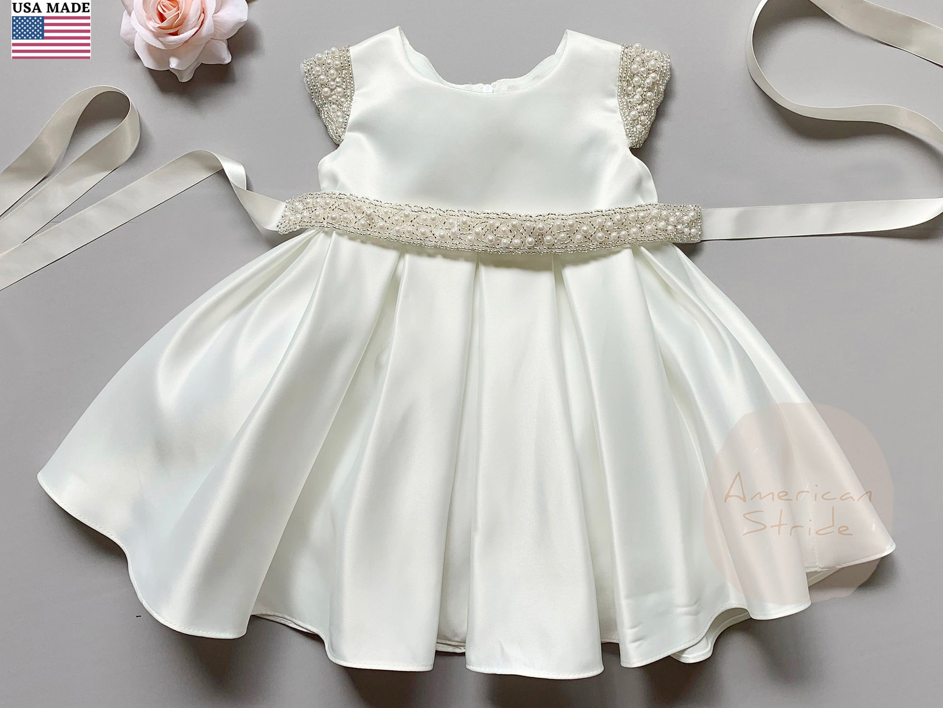 Ivory Flower Girl Beaded Short Sleeves Dull Satin dress with Detachable Pearl Sash - front view of dress with belt, pink flower beside the dress