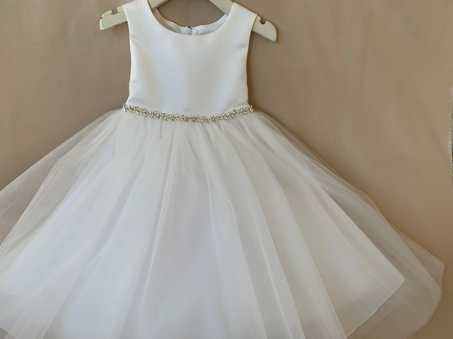 USA Made | Pearl and Rhinestone Light Ivory Flower Girl Dress | Classic Satin and Tulle Flower Girl Dress | Size 6M - Teen - front view of the dress on a hanger