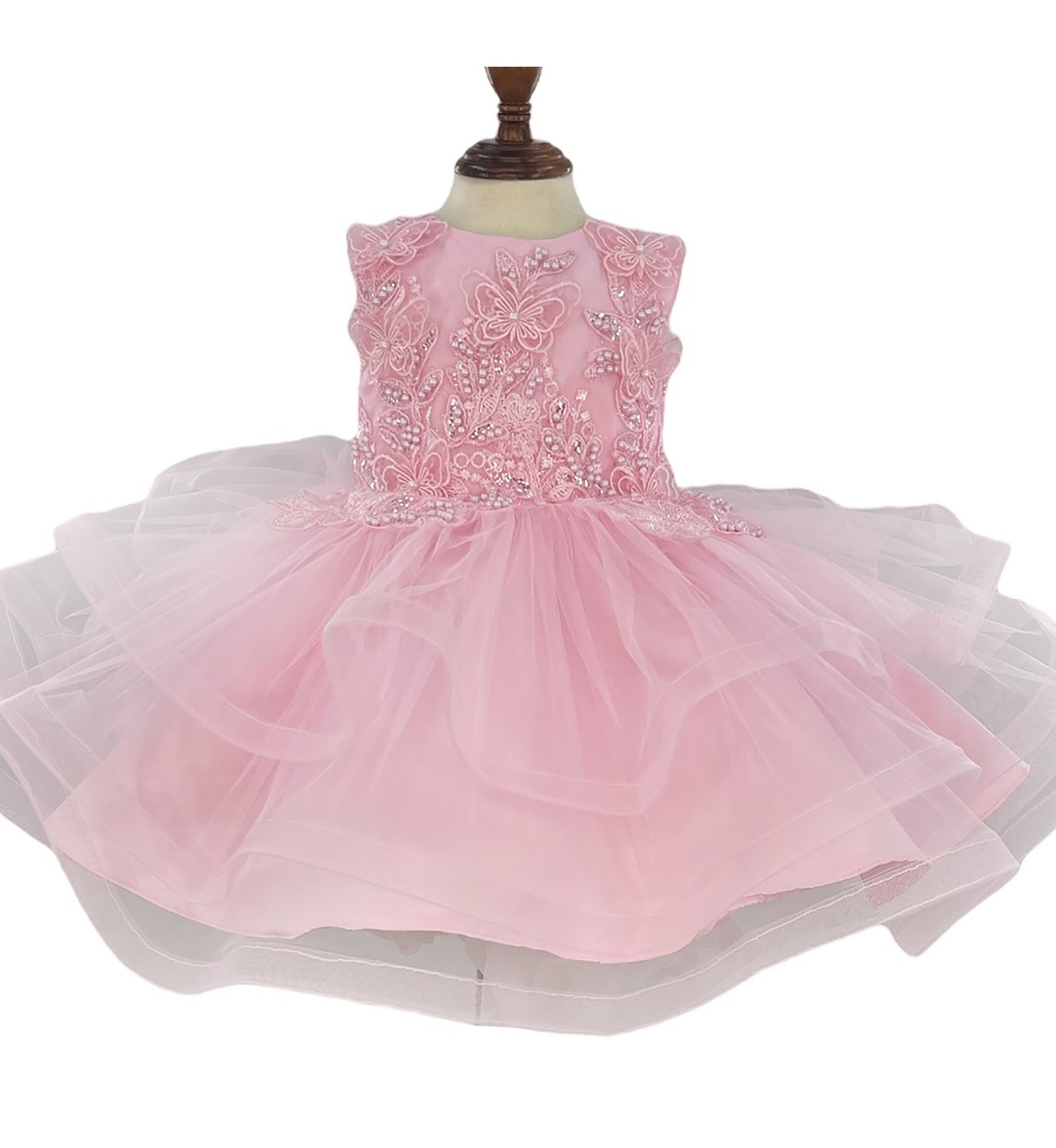 Pink dress with floral embellishments on a mannequin against a white background