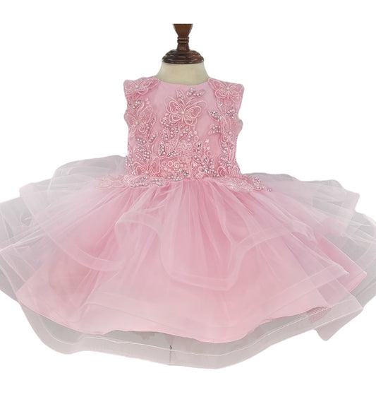 Pink dress with floral embellishments on a mannequin against a white background