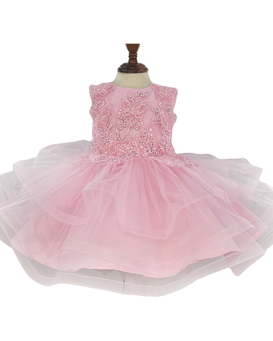 Pink dress with floral embellishments on a mannequin against a white background