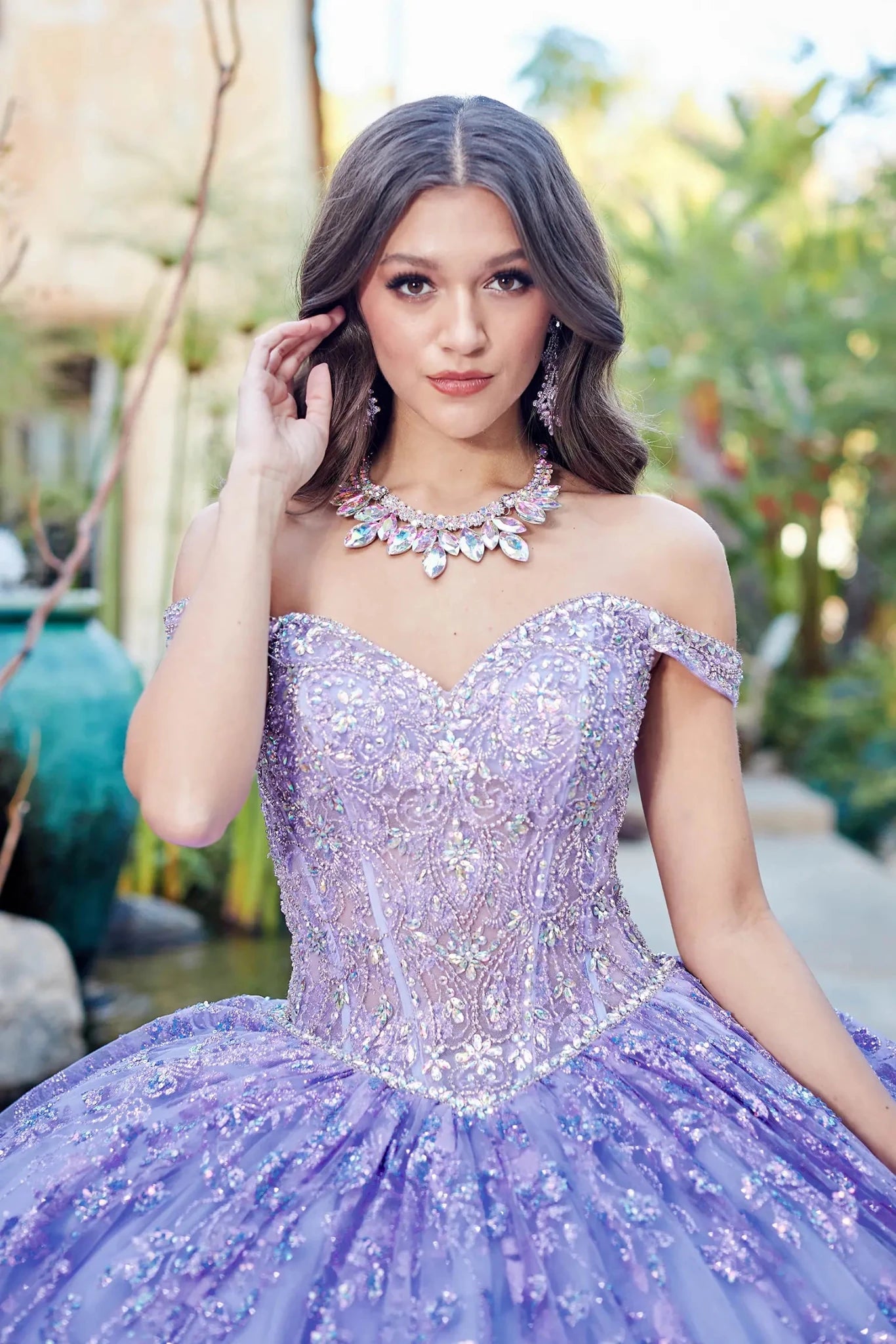 Woman wearing a sparkling purple quince dress with a blurred outdoor background