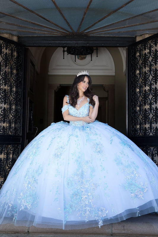Woman in a light blue gown standing in an elegant interior setting