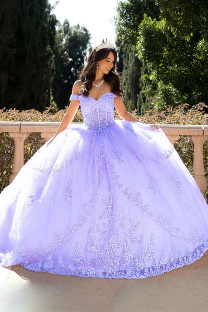 Woman in a lilac ball gown standing outdoors with greenery in the background