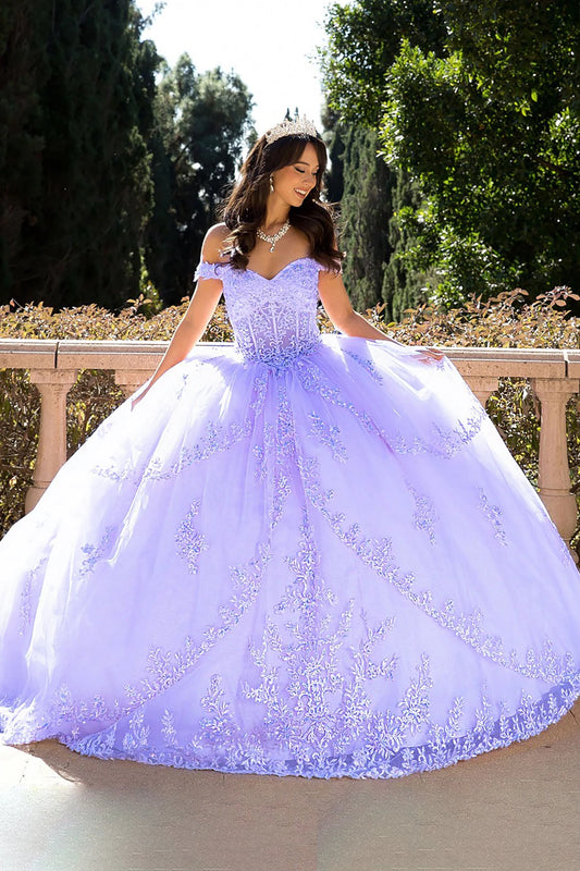 Woman in a lilac ball gown standing outdoors with greenery in the background