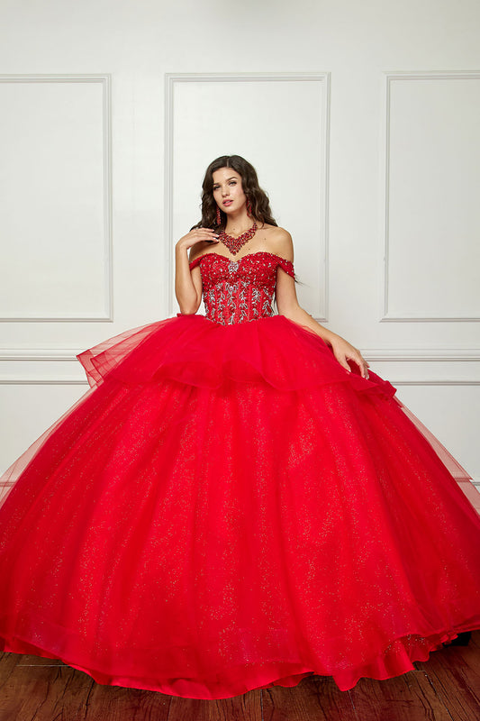 Red ball gown with intricate detailing on a white paneled wall background