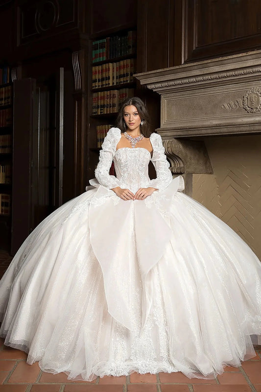 Woman in a white ball gown dress standing in a room with bookshelves and a fireplace.