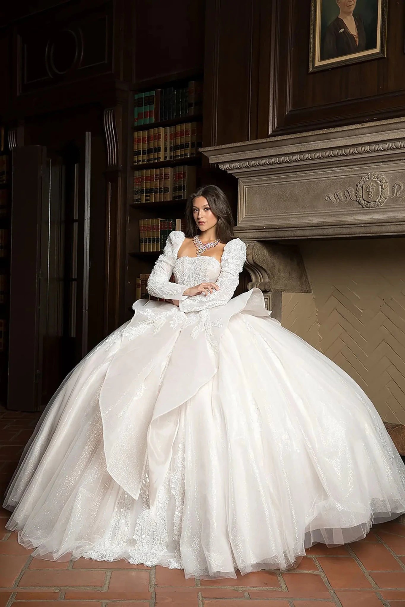Woman in a white wedding dress standing in a room with wooden walls and a fireplace.