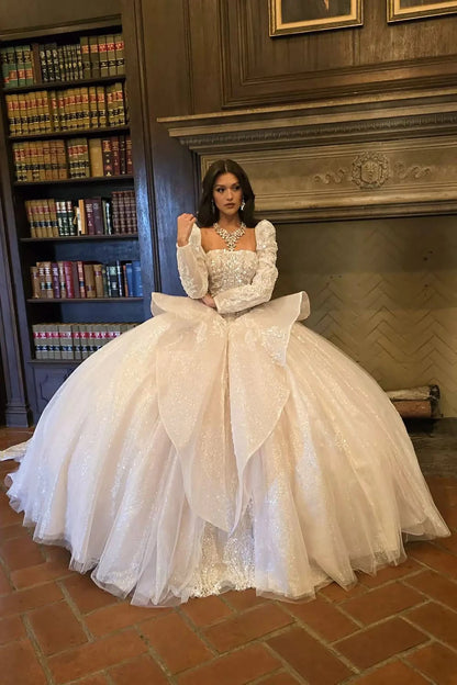 Woman in a white wedding dress standing in a room with wooden paneling and bookshelves.