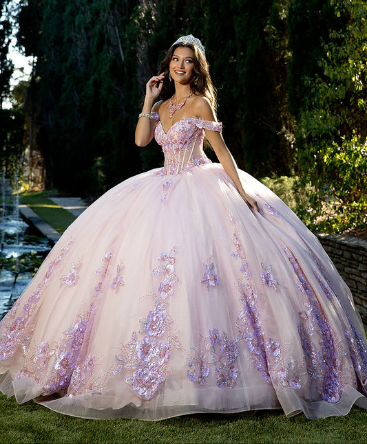 Girl in a pink and lilac floral gown standing outdoors with trees in the background