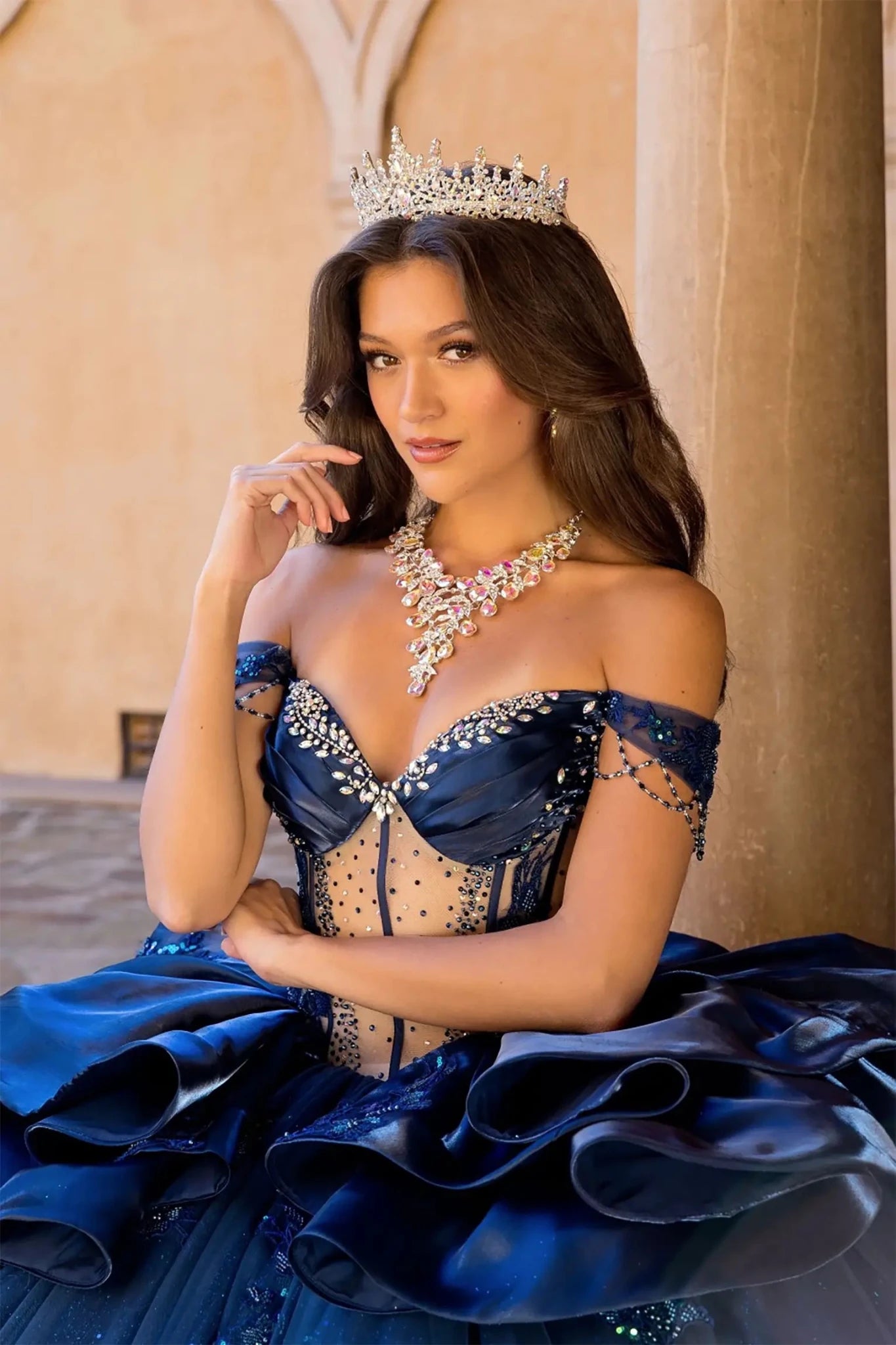 close up a girl in a navy quinceanera ball gown with rhinestone on the top