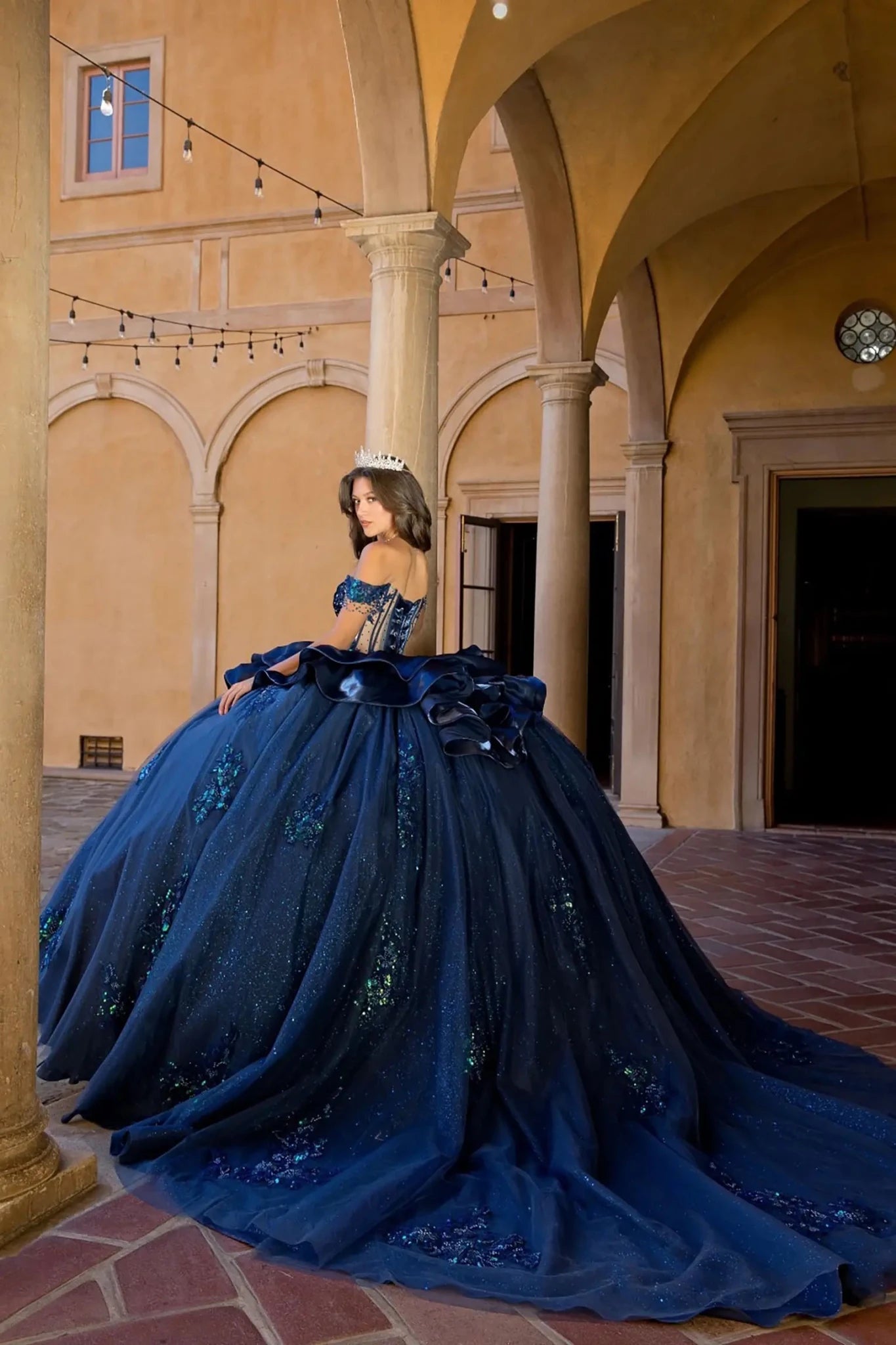 Woman in a navy quinceanera ball gown with long train 