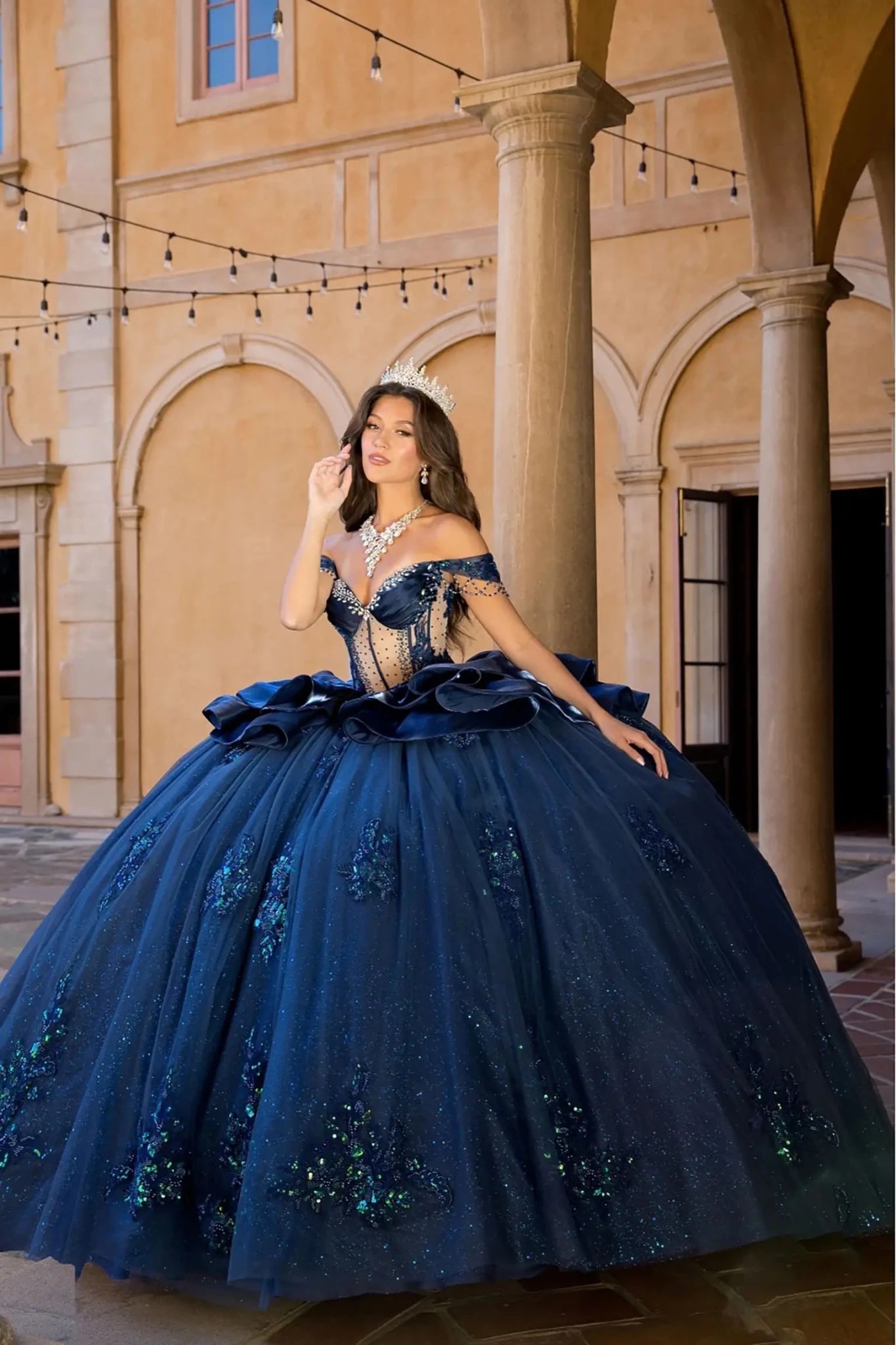 Woman in a navy quinceanera quinceanera ball gown with see though body with rhinestones
