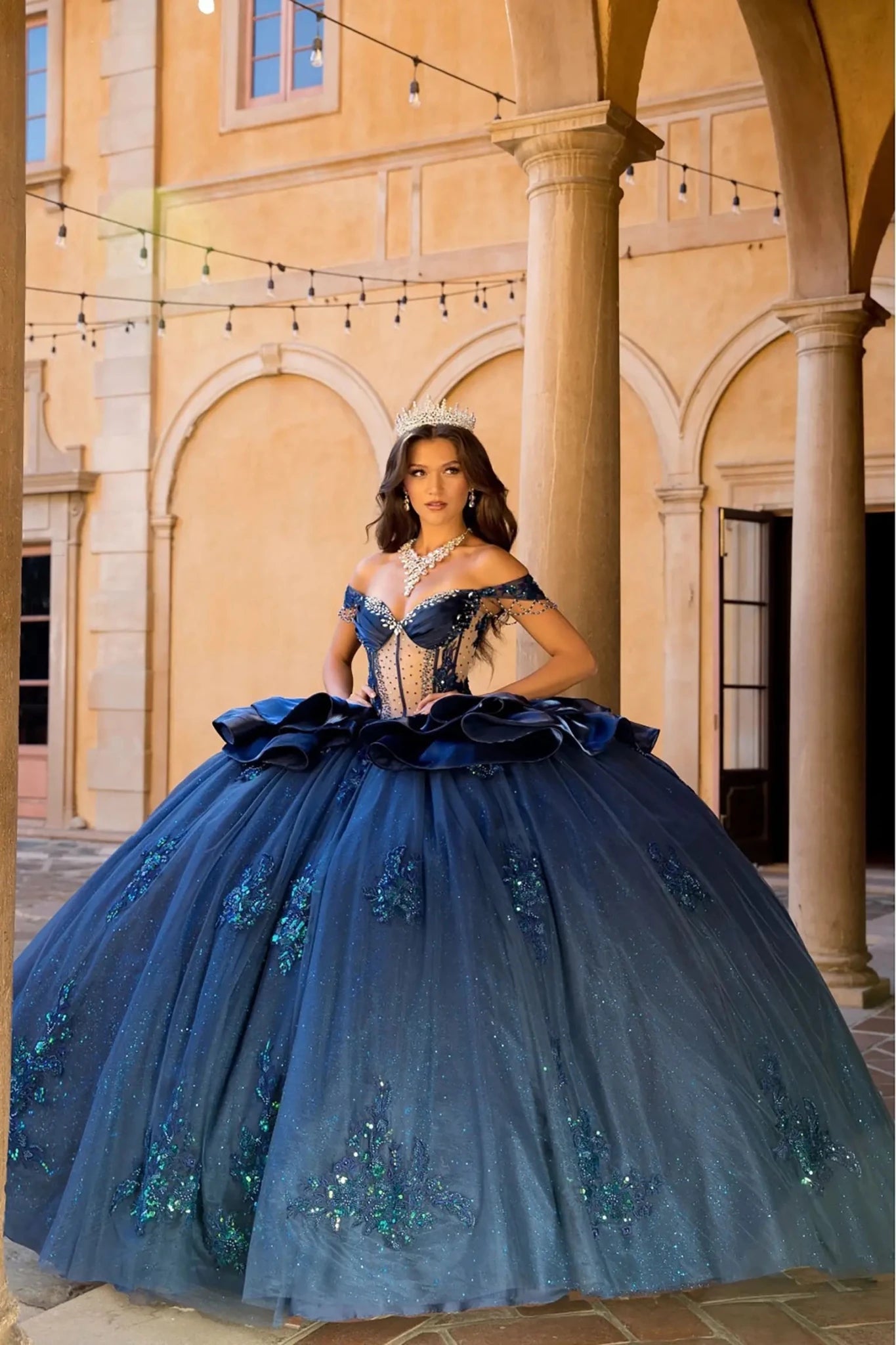 Girl in a navy quinceanera ball gown The embellishments on the skirt sparkle in the light.