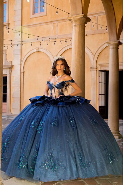 Girl in a navy quinceanera ball gown The embellishments on the skirt sparkle in the light.
