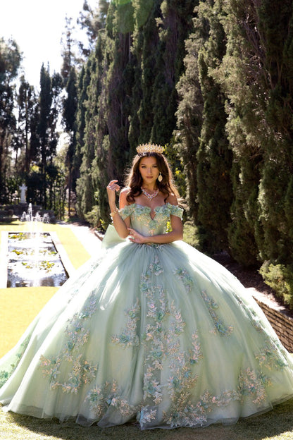 Woman in a floral dress standing outdoors with trees and a garden in the background
