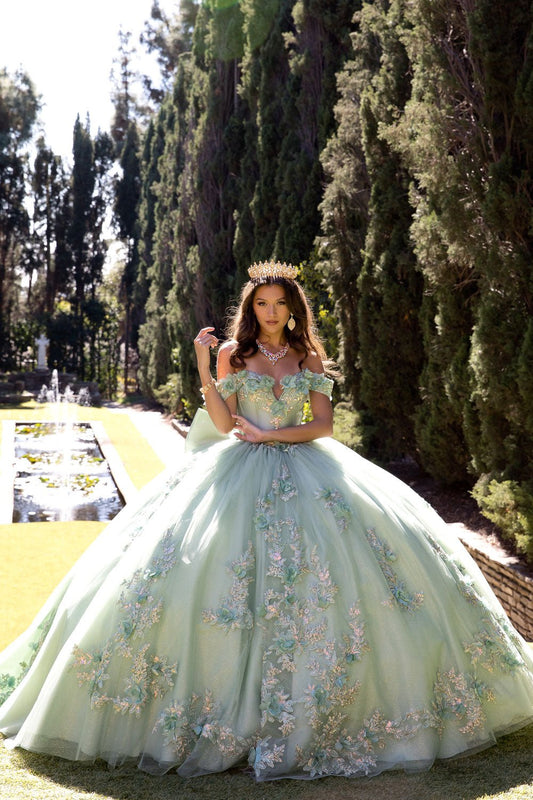 Woman in a floral dress standing outdoors with trees and a garden in the background