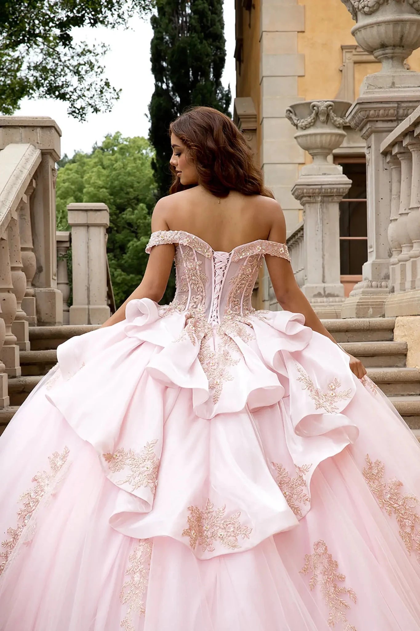 Back view close up image highlights the massive scale of the glitter tulle ball gown skirt and the intricate rose gold floral lace embroidery cascading toward the hem.