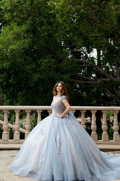 Front view of a woman wearing a light blue quinceañera dress with corset bodice and embroidered details