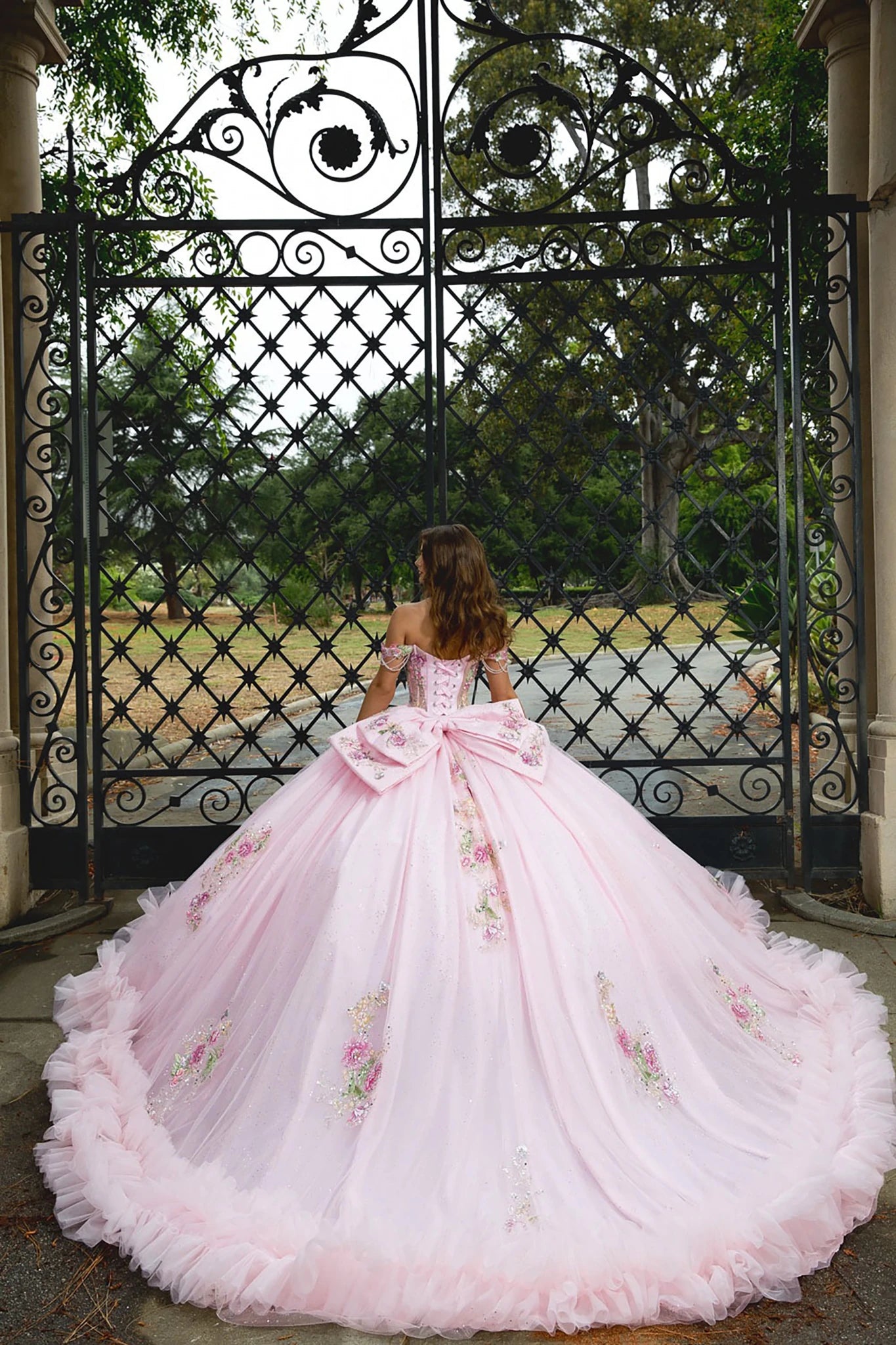 Pink floral gown in front of an ornate black gate