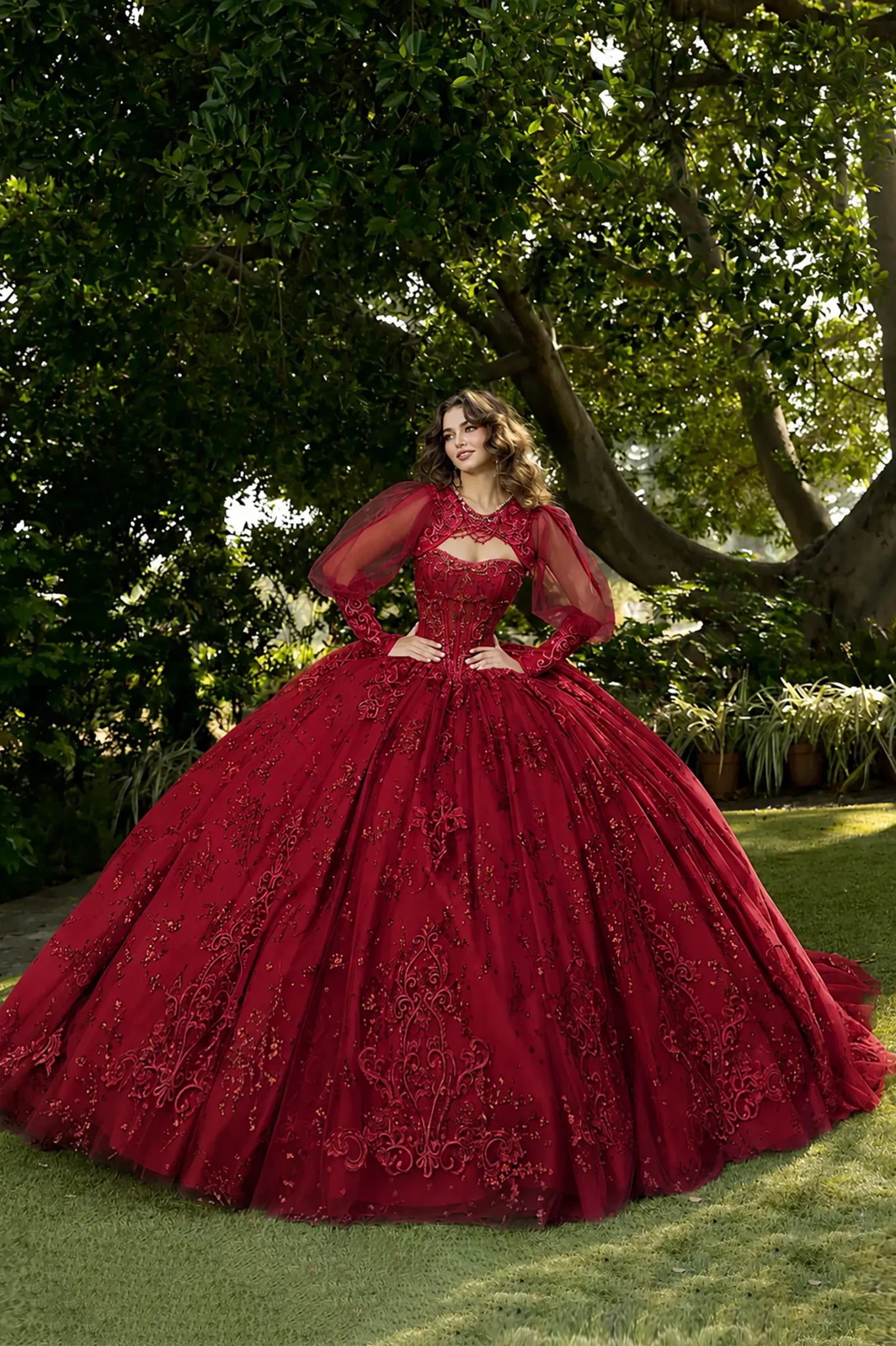 Front view of a woman wearing a red quinceañera dress with lace-up corset, embroidered see-through bodice and glitter tulle skirt
