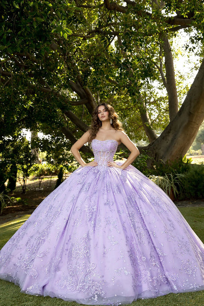 Front view of a woman wearing a lilac quinceañera dress with glitter tulle skirt, embroidered see-through bodice and matching bolero jacket
