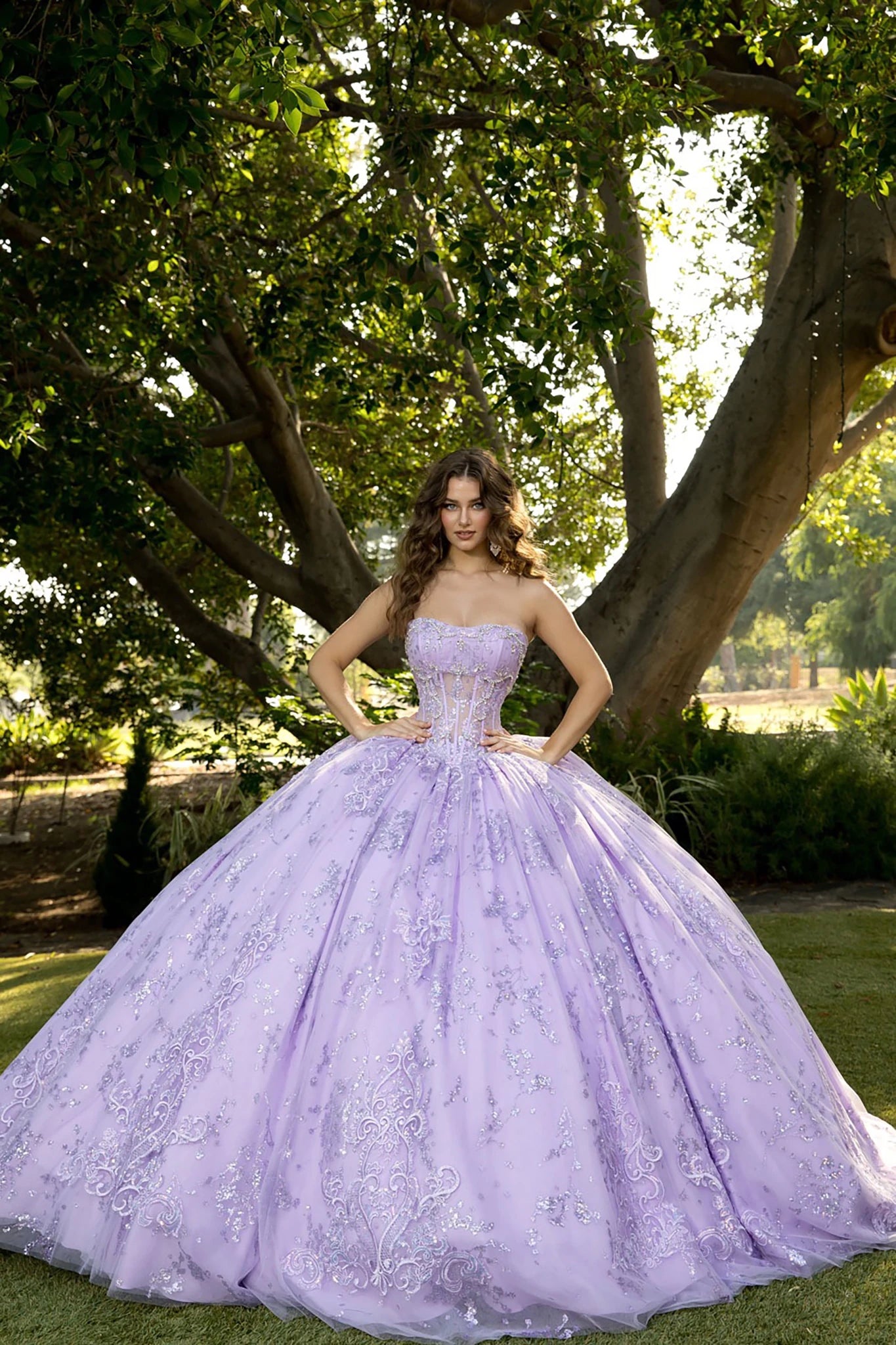 Front view of a woman wearing a lavender quinceañera dress with corset bodice and layered skirt